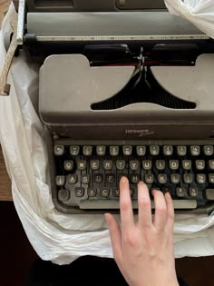 a person typing on an old fashioned typewriter