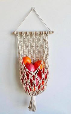 apples and oranges in a hammock hanging on the wall with macrame