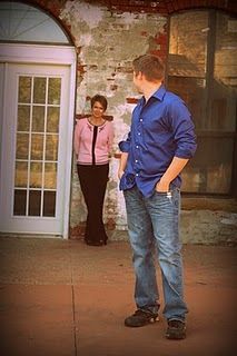 a man standing in front of a door next to a woman with her hands on her hips