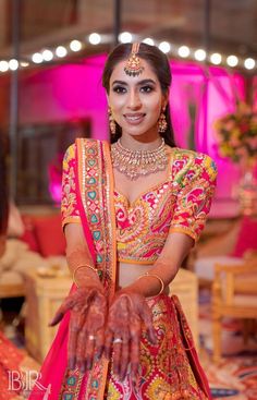 a woman in a red and gold bridal outfit