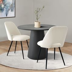 a round table with two white chairs and a potted plant on the top in front of it