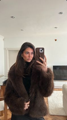 a woman is taking a selfie with her cell phone while sitting on a couch