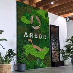 the interior of an office building decorated with green plants and artificial wall art that says arbor