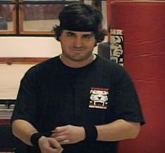 a man standing next to a punching bag