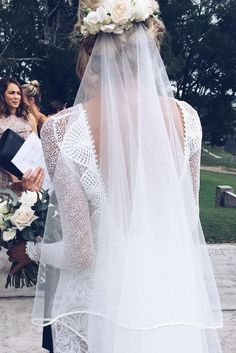 the back of a bride's veil as she walks down the aisle with her groom