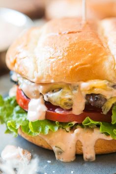 a cheeseburger with tomatoes, lettuce and other toppings on it