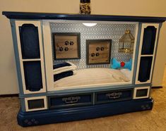 a blue and white bed frame with dog paw prints on the wall above it is an entertainment center