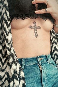 a woman with a cross tattoo on her chest