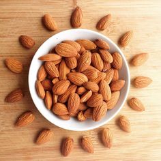 a white bowl filled with almonds on top of a wooden table