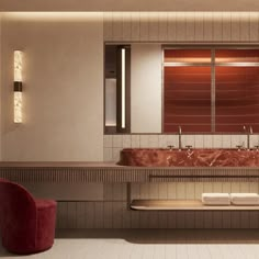 a bathroom with two sinks and a red chair