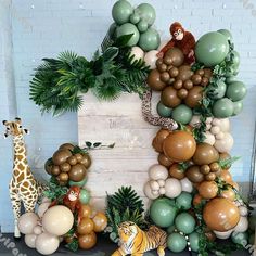 an animal themed backdrop with balloons and jungle animals