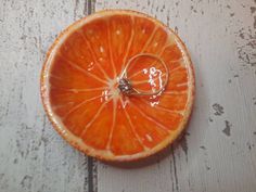 an orange sliced in half with a ring on it