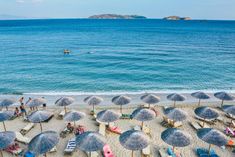 many umbrellas and chairs are on the beach