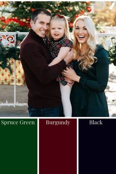 a man and woman holding a child in front of a christmas tree with red, green, and black colors