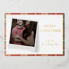 a christmas card with an image of a man and woman hugging each other on top of a marble surface