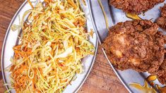 two trays filled with food on top of a wooden table