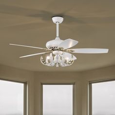 a ceiling fan in a living room with three windows