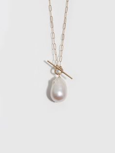 This necklace brings together the contrasting elements of delicate open oval links of 14Kt yellow gold chain, a charming toggle bar front closure, and a dramatic baroque teardrop pearl pendant to create a luxe piece with unique details. 14Kt Yellow Gold Long Link Chain 14x17mm Teardrop Baroque Pearl Length: 16" Made in L.A. Globally Sourced Materials Each pearl is unique, no two are exactly the same. Baby Pearls, Toggle Necklace, Wide Band Rings, Yellow Gold Chain, Pearl Choker, Bracelet Collection, Silver Pieces, Gold Hoops, Baroque Pearls