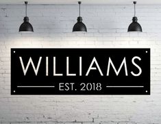 a sign that says williams est 2013 hanging from the ceiling in front of a brick wall