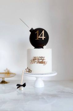 a white and black cake with gold numbers on it sitting on top of a table