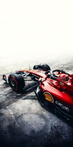 a red race car sitting on top of a cement floor