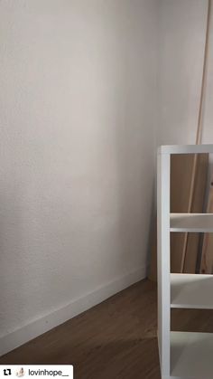 a white book shelf sitting in the corner of a room