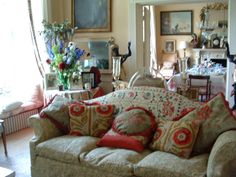 a living room filled with lots of furniture and flowers in vases on the table