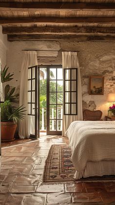 a bedroom with stone walls and doors leading to an outside patio