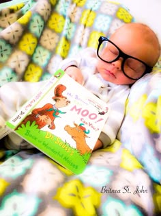 a baby wearing glasses is reading a book