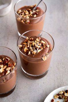 three glasses filled with chocolate pudding and nuts