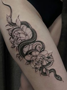 a woman's thigh with a snake and roses tattoo on it