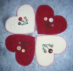 four red and white heart shaped rugs with buttons in the shape of flowers on them