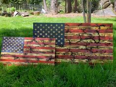 three wooden american flags sitting in the grass