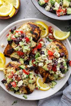 grilled chicken with cucumber, tomato and feta salad on a white plate