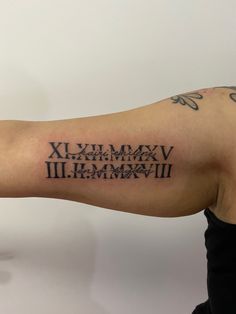 a person with a tattoo on their arm has the words roman numerals written in black ink