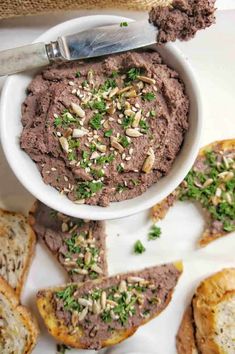 a white bowl filled with hummus next to toasted bread