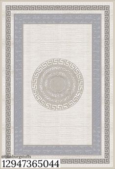 a white and blue area rug with an intricate design on the center, in front of a