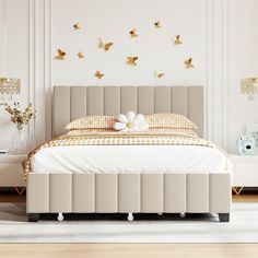 a bedroom with a bed, dresser and mirror in the corner is decorated with gold butterflies