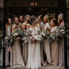 a group of women standing next to each other in front of a building with flowers