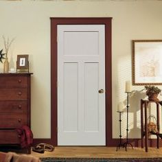 a living room with a white door and brown trim on the wall, carpeted floor