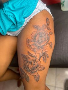 a close up of a person's thigh with tattoos on it and flowers in the middle