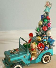 a toy truck with a christmas tree in the back and other ornaments on the top