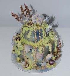 a multi - tiered cake decorated with flowers and plants