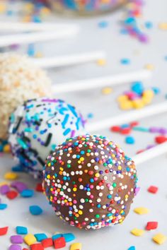 three cake pops with sprinkles on them