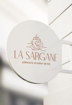 a white sign hanging from the side of a building that says la sargane