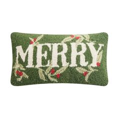 a green christmas pillow with the word merry on it