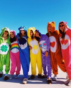 a group of people in costumes standing next to each other on top of a sandy beach