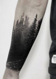 a man with a forest tattoo on his arm