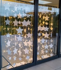 two glass windows decorated with stars and string lights