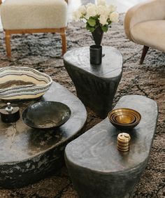 a living room filled with furniture and a vase on top of a table next to two chairs